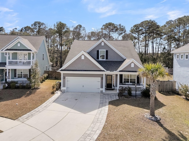 view of front of house with covered porch, fence, concrete driveway, and roof with shingles