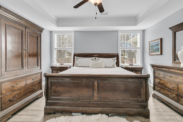 bedroom featuring visible vents, a tray ceiling, and ornamental molding