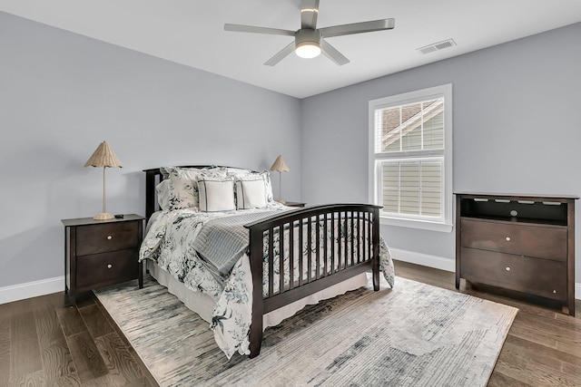 bedroom with baseboards, visible vents, ceiling fan, and wood finished floors