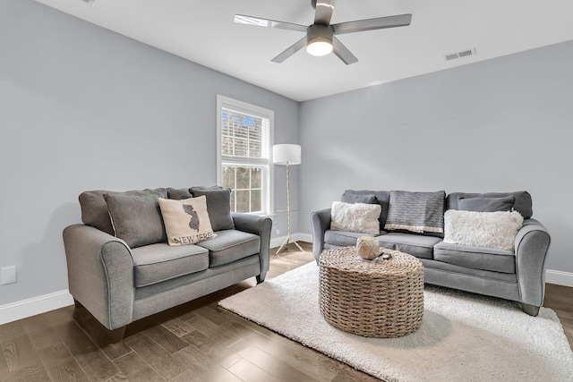 living area with visible vents, baseboards, and wood finished floors