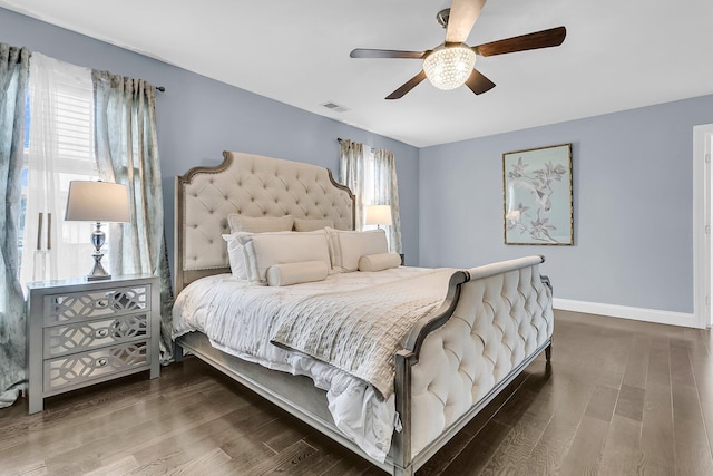 bedroom featuring ceiling fan, wood finished floors, visible vents, and baseboards