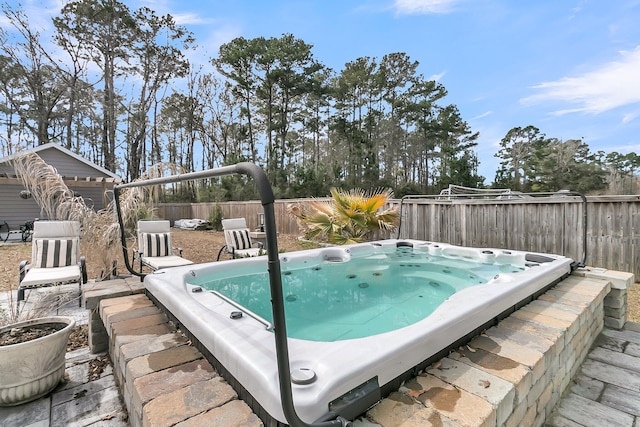 view of pool featuring a fenced backyard and an outdoor hot tub