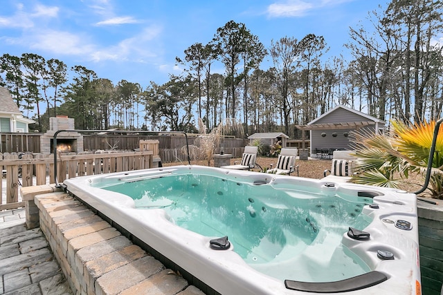 view of swimming pool with an outdoor structure, fence, and an outdoor hot tub