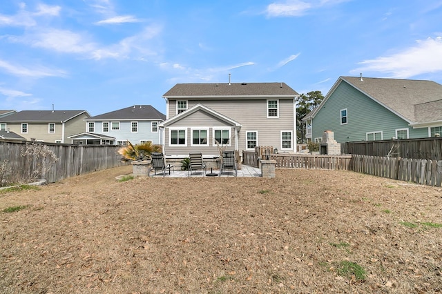 back of house featuring a fenced backyard, a residential view, and a patio