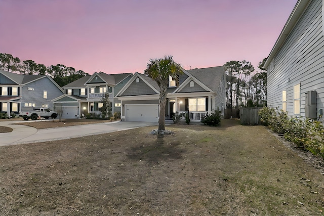 view of front of home with a garage, concrete driveway, and a porch