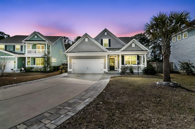 view of front of home with driveway, covered porch, and a garage