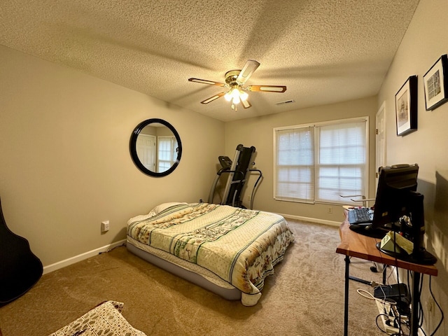 carpeted bedroom featuring a ceiling fan, visible vents, a textured ceiling, and baseboards