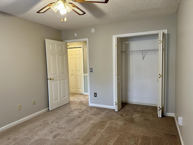 unfurnished bedroom with carpet floors, a closet, a textured ceiling, and baseboards