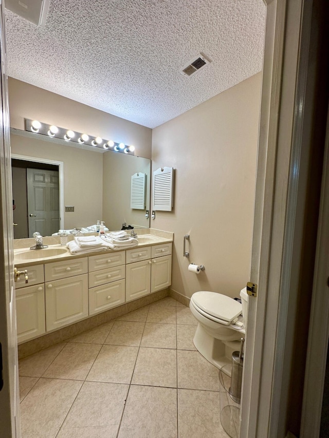 full bath with double vanity, visible vents, a sink, and tile patterned floors