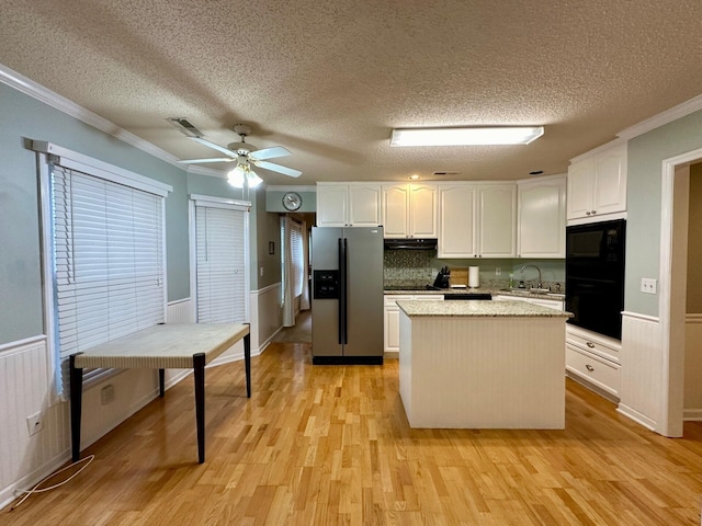 kitchen featuring a kitchen island, white cabinetry, stainless steel refrigerator with ice dispenser, and wainscoting