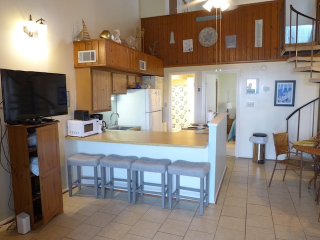 237 Driftwood Ln, Edisto Island, SC 29438 - kitchen with light tile patterned floors, white appliances, a peninsula, visible vents, and a sink