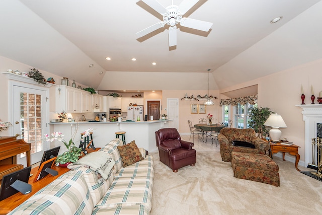 living room with light carpet, lofted ceiling, a high end fireplace, and ceiling fan