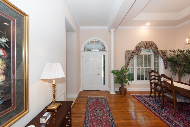 entrance foyer with decorative columns, wood-type flooring, and ornamental molding