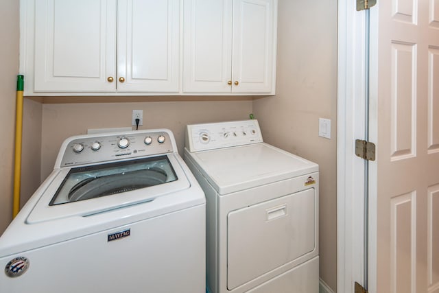 washroom with cabinets and washing machine and dryer