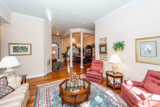 living room with crown molding, ornate columns, and hardwood / wood-style flooring