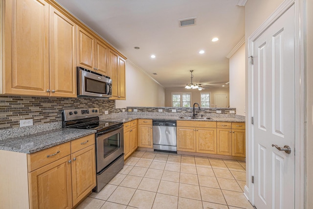 kitchen with ornamental molding, light tile patterned flooring, appliances with stainless steel finishes, and a sink