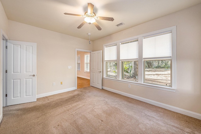 unfurnished bedroom featuring visible vents, ceiling fan, baseboards, and light carpet