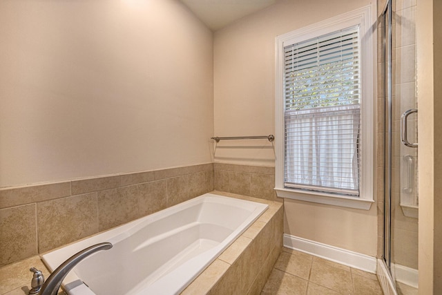 bathroom featuring baseboards, a shower stall, a garden tub, and tile patterned flooring