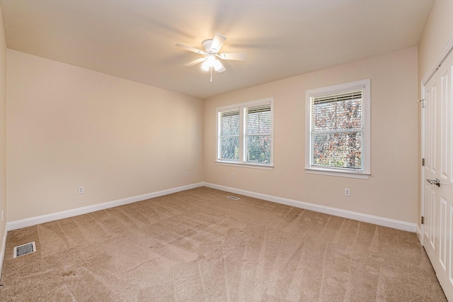 unfurnished bedroom featuring baseboards, visible vents, and light colored carpet
