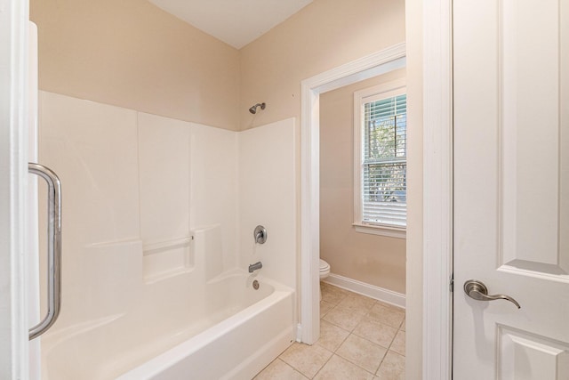 full bath featuring shower / washtub combination, toilet, tile patterned flooring, and baseboards