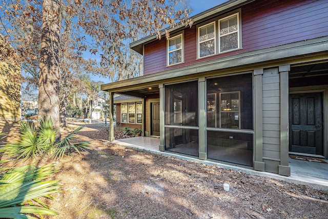 back of property with a sunroom