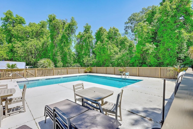 community pool with fence and a patio area