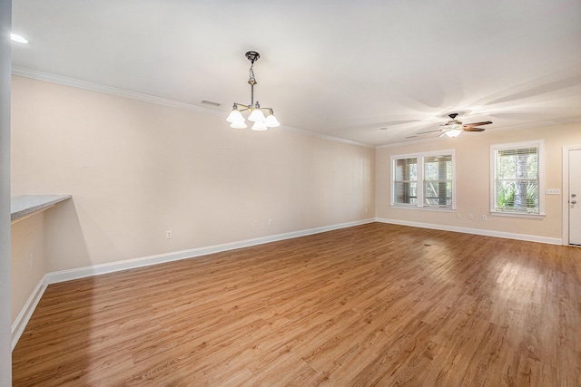 unfurnished room featuring ceiling fan with notable chandelier, light wood finished floors, baseboards, visible vents, and crown molding