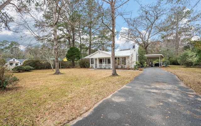 ranch-style house with a front lawn, a carport, and a porch