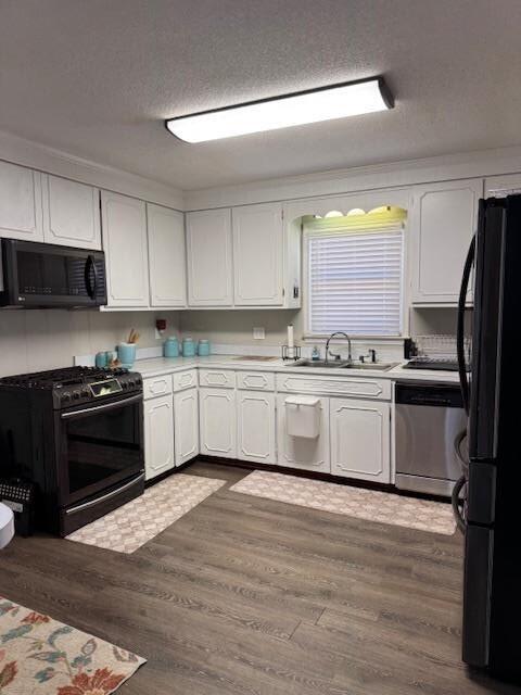 1188 Blackberry Bush Rd, Summerton, SC 29148 - kitchen with white cabinets, a sink, and black appliances