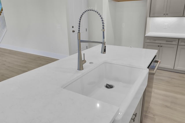 3029 Robeson Trce, Johns Island, SC 29455 - detailed view of a sink, light wood-style floors, gray cabinets, and dishwasher