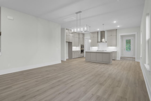 3029 Robeson Trce, Johns Island, SC 29455 - kitchen with wall chimney exhaust hood, light wood-style flooring, open floor plan, light countertops, and baseboards