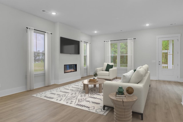 3029 Robeson Trce, Johns Island, SC 29455 - living area featuring light wood-style floors, baseboards, a glass covered fireplace, and recessed lighting