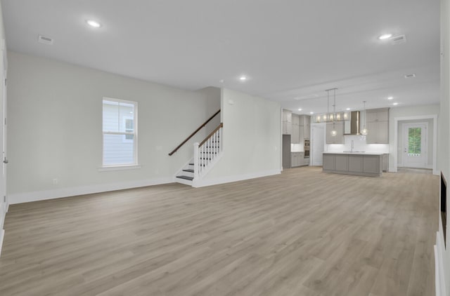 3029 Robeson Trce, Johns Island, SC 29455 - unfurnished living room featuring baseboards, light wood-type flooring, plenty of natural light, and recessed lighting