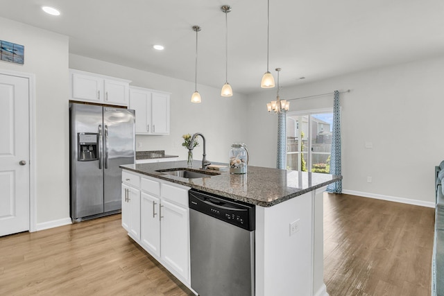 9706 Fanning Basket Ln, Ladson, SC 29456 - kitchen with a center island with sink, light wood-type flooring, dark stone counters, a sink, and stainless steel appliances