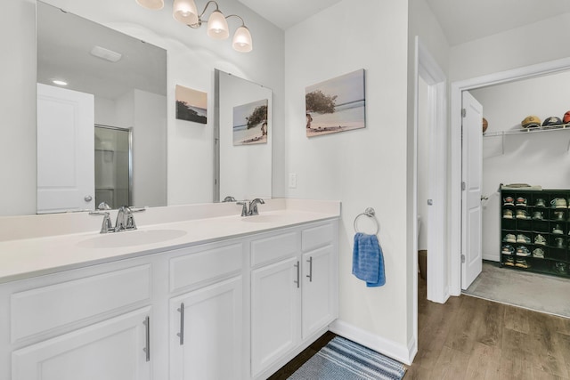 9706 Fanning Basket Ln, Ladson, SC 29456 - bathroom with double vanity, a shower with door, wood finished floors, baseboards, and a sink