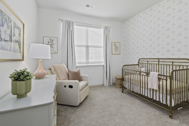 carpeted bedroom featuring wallpapered walls, baseboards, visible vents, and a nursery area