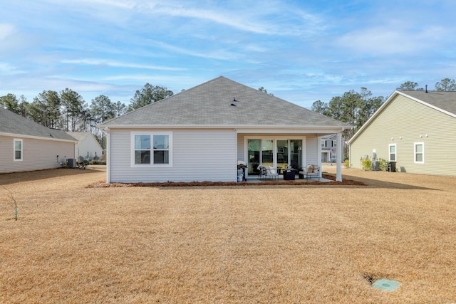 rear view of house featuring roof with shingles, a patio area, and cooling unit