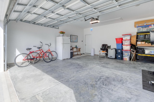 garage featuring a garage door opener and freestanding refrigerator