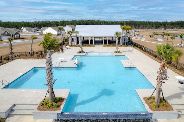 pool with a patio and fence