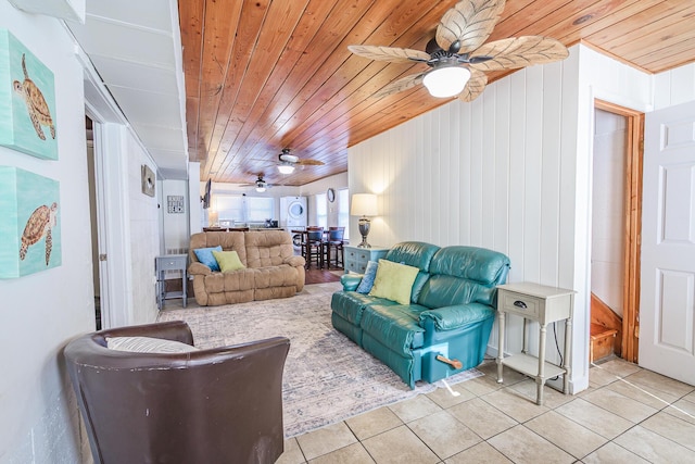 living room with wooden walls, wooden ceiling, and light tile patterned floors