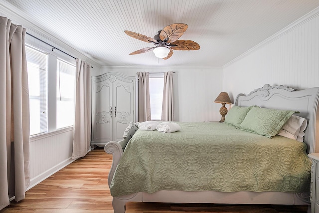 bedroom with light wood-type flooring, ceiling fan, and crown molding