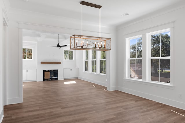 unfurnished living room with ornamental molding, ceiling fan with notable chandelier, and hardwood / wood-style flooring