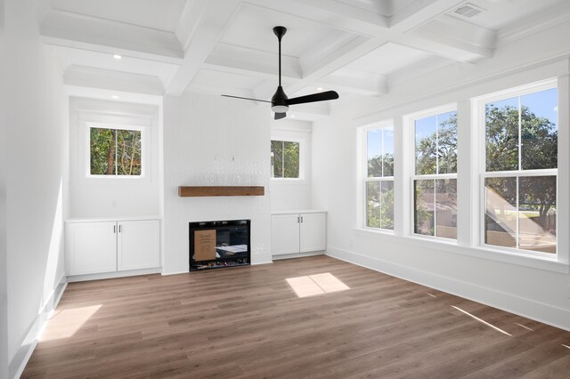 unfurnished living room featuring beamed ceiling, dark hardwood / wood-style floors, and a large fireplace