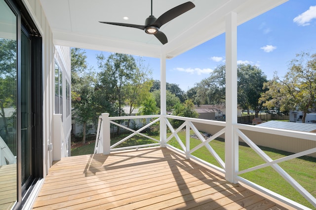 wooden terrace with ceiling fan and a yard