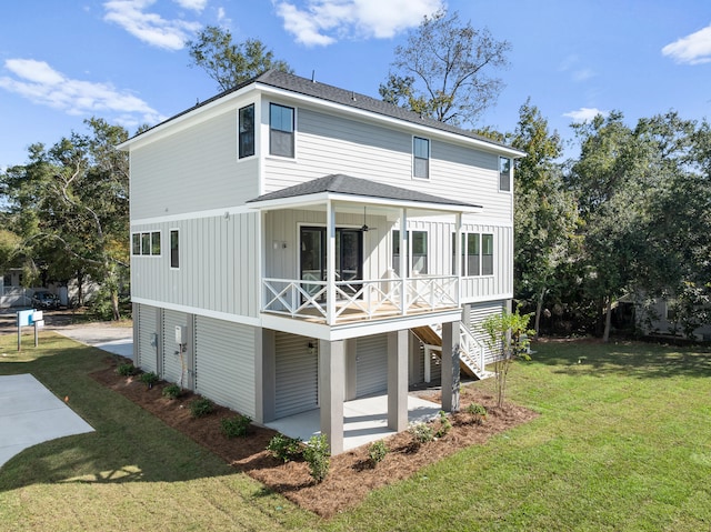 rear view of property featuring ceiling fan, a patio area, and a yard