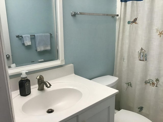 bathroom with a shower with shower curtain, vanity, and toilet