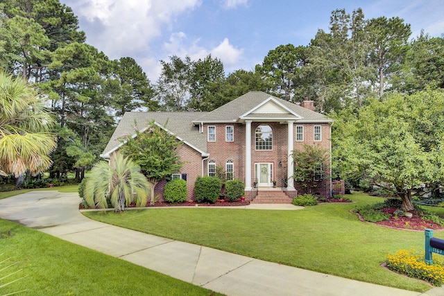 neoclassical / greek revival house featuring a front lawn