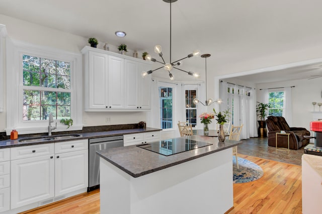 kitchen with light wood-type flooring, dishwasher, hanging light fixtures, a center island, and sink