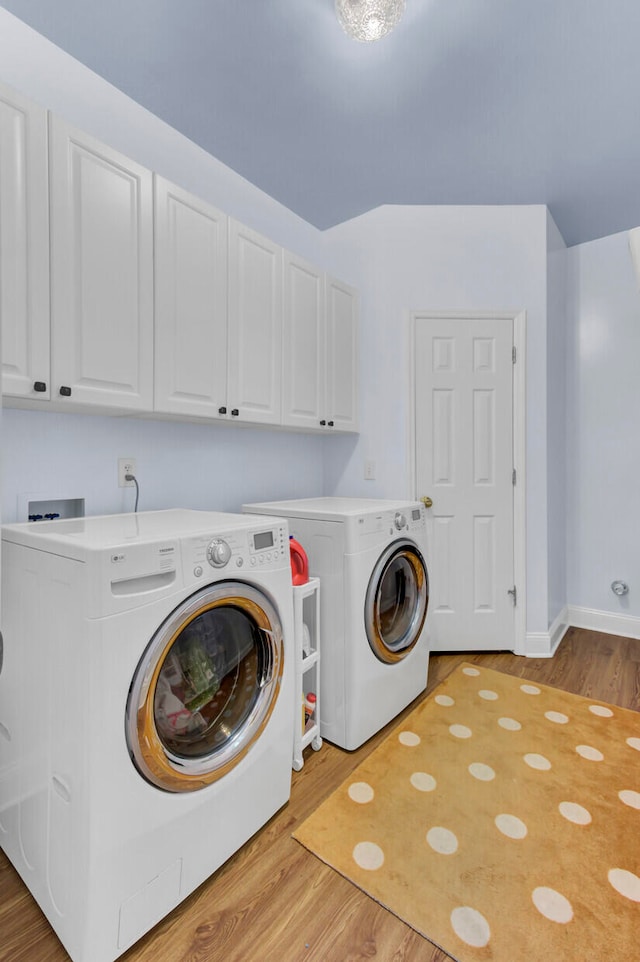 laundry room featuring light wood-type flooring, independent washer and dryer, and cabinets