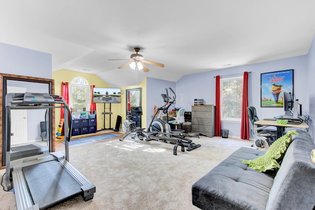 exercise room featuring ceiling fan, light colored carpet, and vaulted ceiling